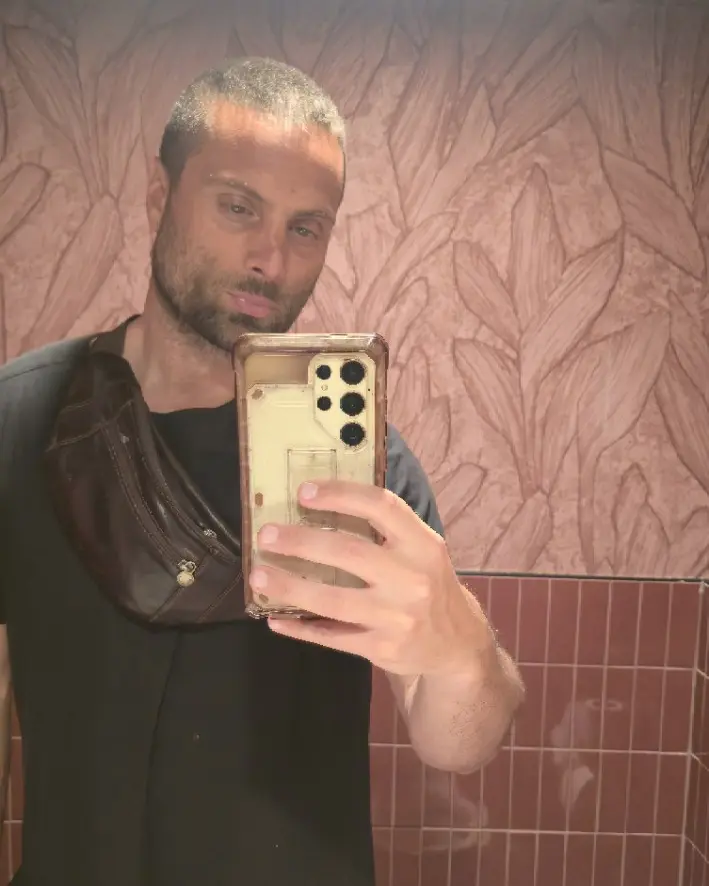 Paul Lizzi onsite at Mare, dressed in black against rose-toned patterned walls.