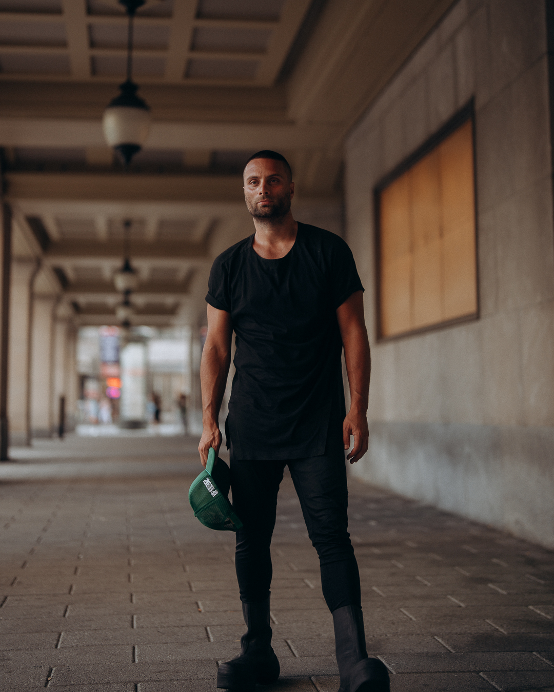 Paul Lizzi standing in a Montréal corridor holding a green cap